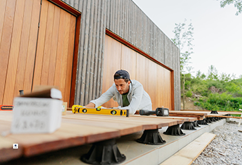 Skilled carpenter installing composite decking boards in Studio City